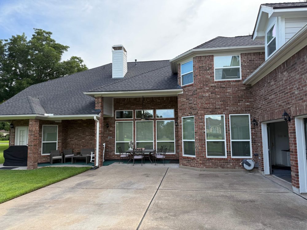 Exterior of a two story brick home with new construction vinyl windows installed.