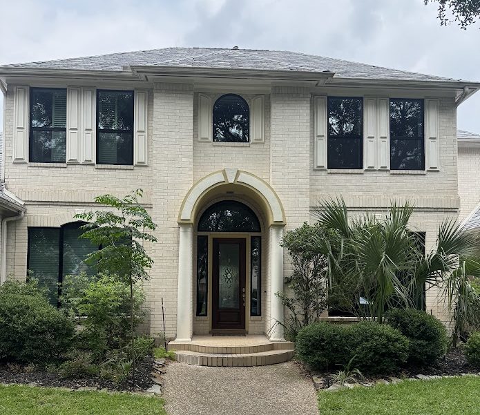 Front view of a traditional two story home with new aluminum windows installed.
