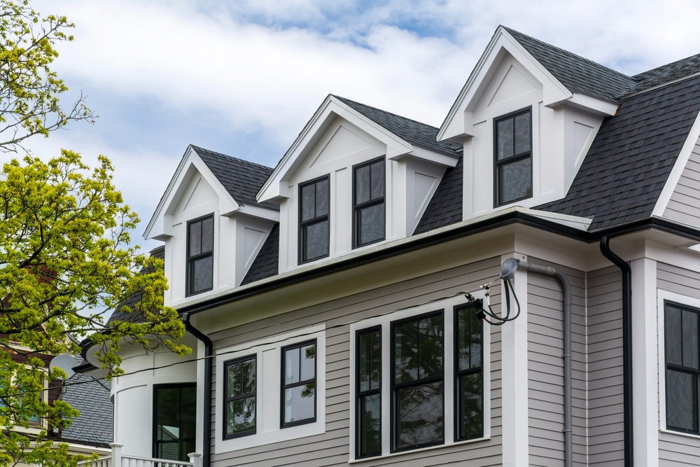 Contemporary house exterior featuring gray siding and black-framed windows in Boston, Massachusetts, USA.