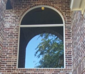 custom shaped arched window on brick home