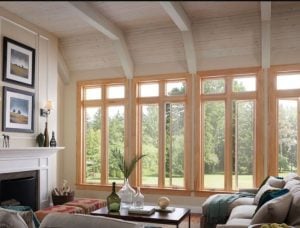 Interior of a modern living room with large wood clad windows.