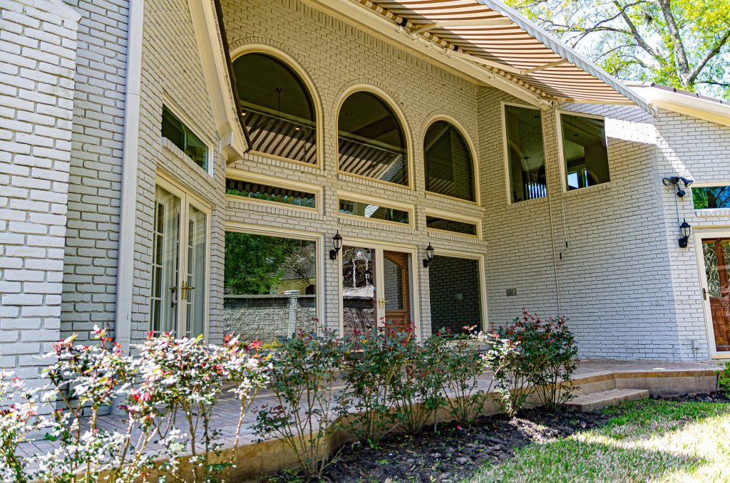 Exterior view of an elegant home with a custom window design installed.