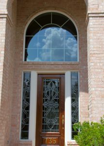 Modern home with a fixed window with arc and door with two side panels.