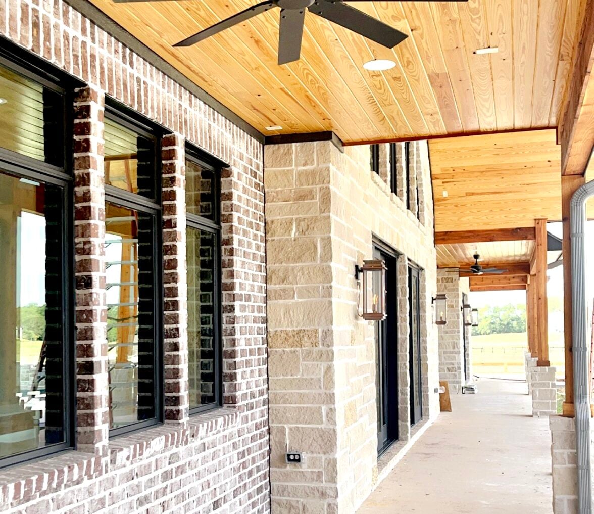 Exterior view of a newly renovated brick home with black wood clad windows installed.